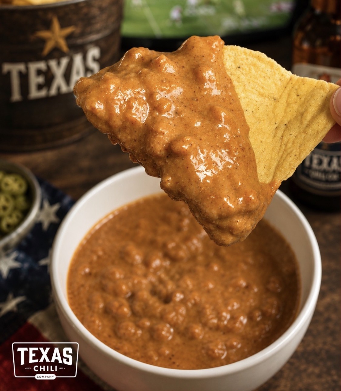 Tortilla chip dipped in Texas Chili Company queso