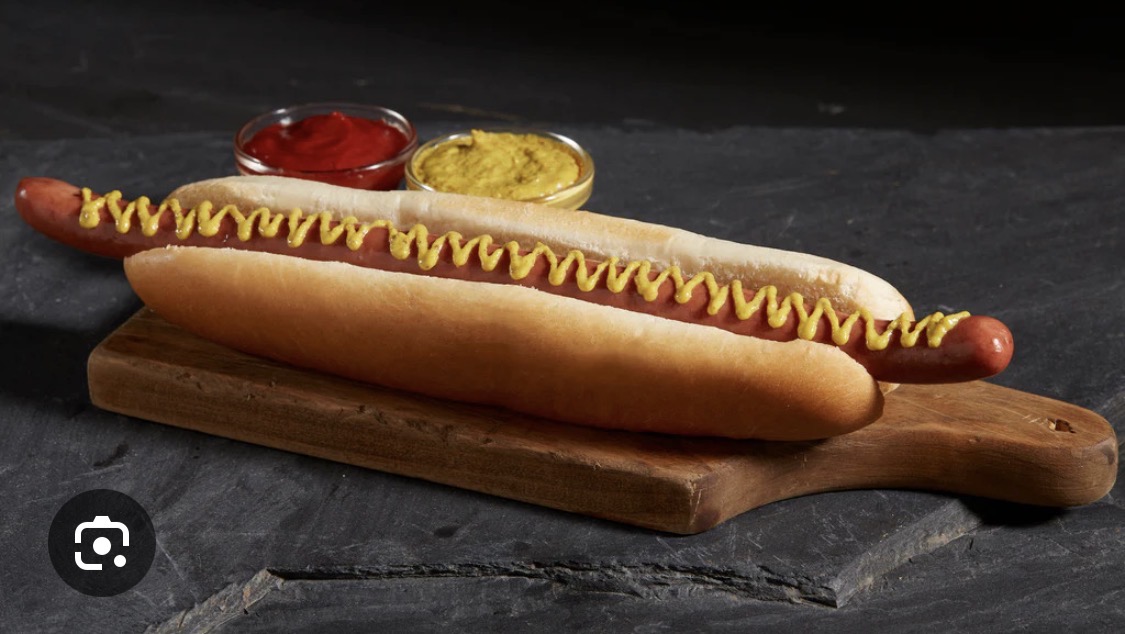 Classic hot dog with mustard on a wooden board